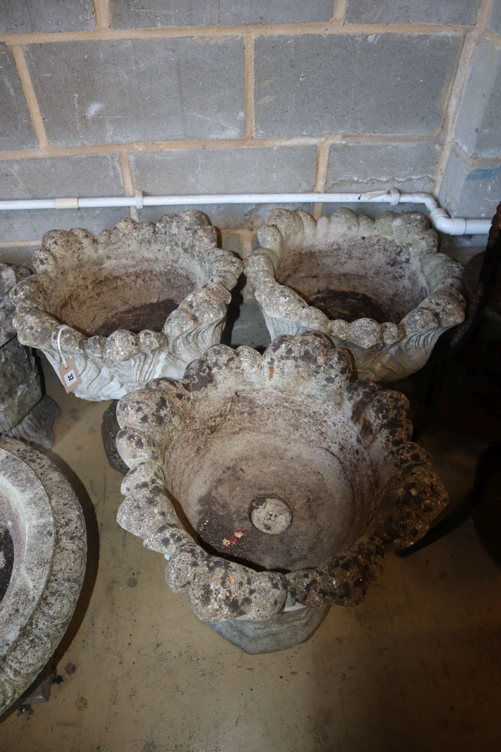 A set of three reconstituted stone campana garden urns, 50cm diameter, H.58cm